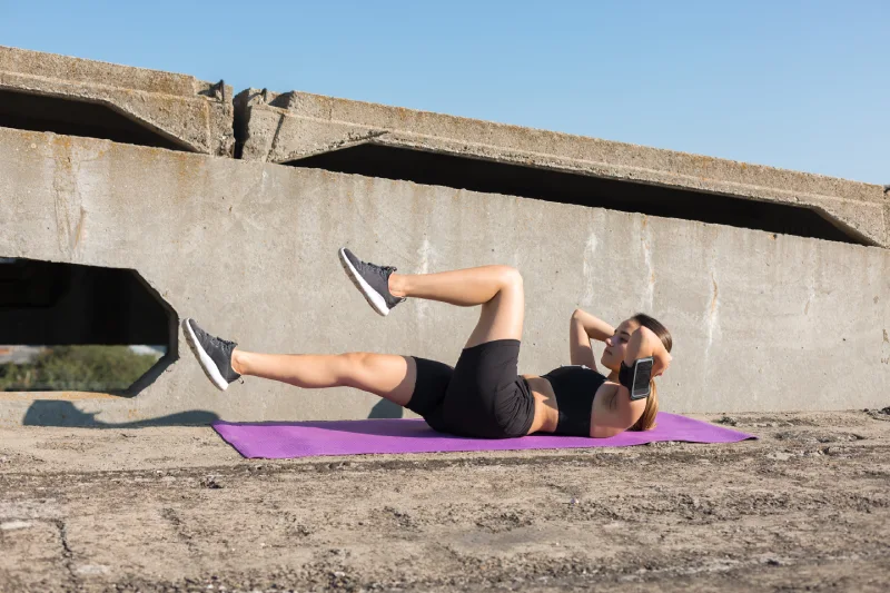 Zestaw hantli i kettlebell ustawiony na macie do ćwiczeń w domowej siłowni