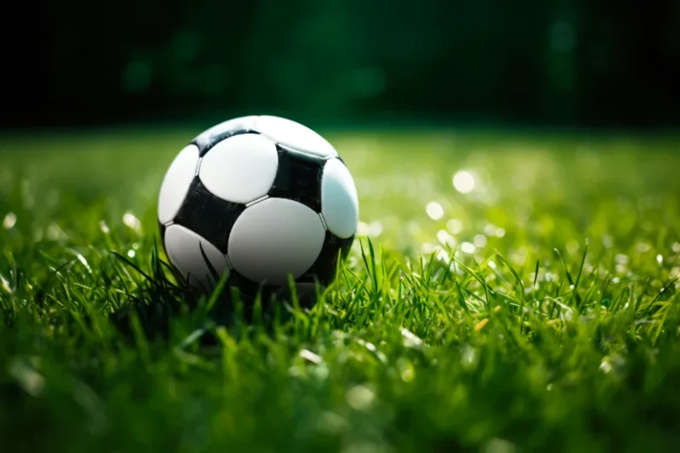 Piłka nożna leżąca na murawie stadionu, akcesoria do treningu piłki nożnej