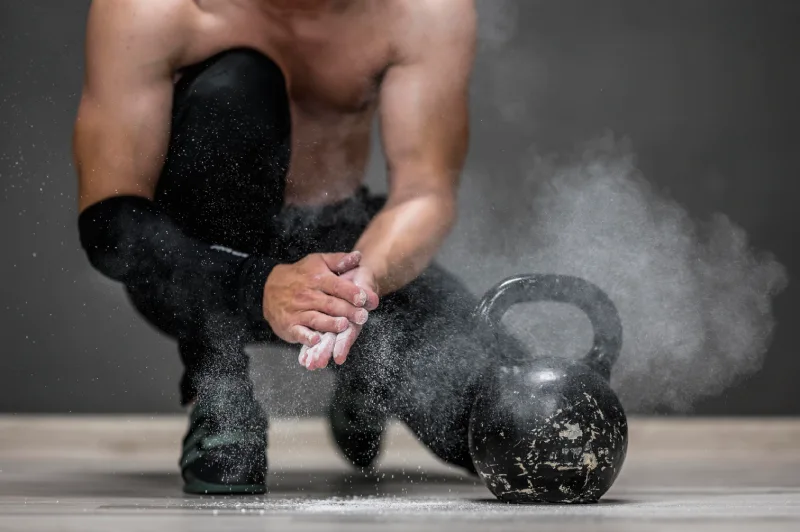 Mężczyzna przygotowujący się do treningu z kettlebell w domowej siłowni