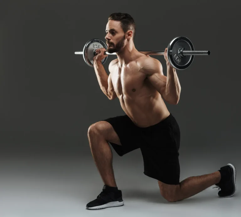 Mężczyzna z gryfem i obciążnikami podczas treningu siłowego w domowej siłowni