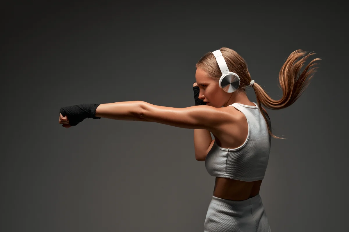 Kobieta ćwicząca walkę z cieniem w dynamicznym treningu domowym, idealne ćwiczenie na poprawę kondycji i siły.