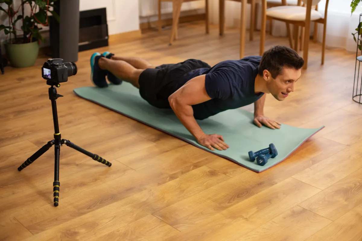 Mężczyzna wykonujący pompki w domu, doskonalący technikę ćwiczeń. Skuteczny trening bez sprzętu, poprawna forma i unikanie błędów treningowych.