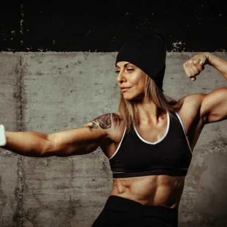 Młoda kobieta prezentuje mięśnie po treningu domowym