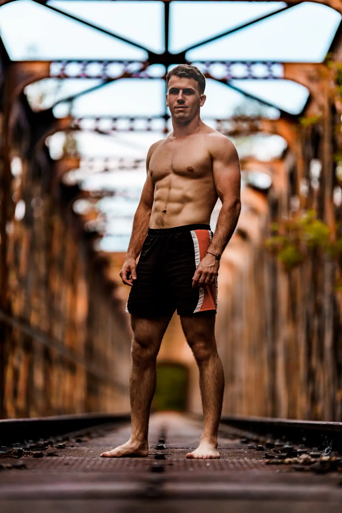 atrakcyjny facet prezentuje umięśnione ciało w plenerze po treningu według najnopwszych trendóœ fitness 2025 animal flow